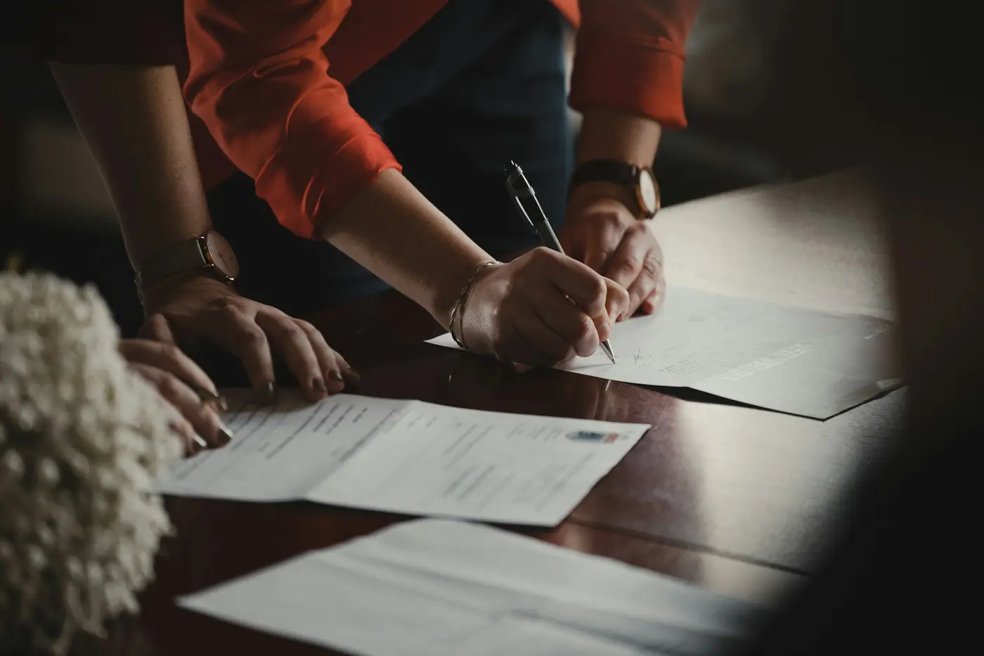 Two people signing a loan agreement at a desk